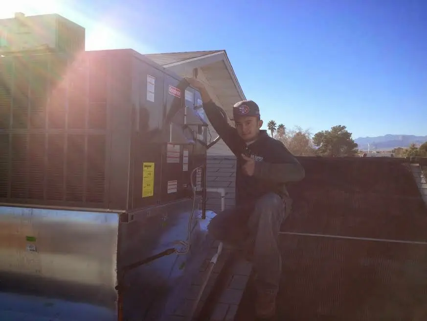 HVAC technician performing AC Tune-Up on a rooftop unit in Treasure Island